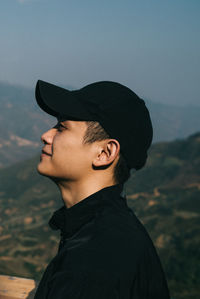 Portrait of young man standing against sky