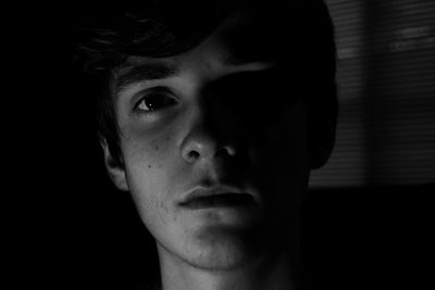 Close-up of portrait of serious man in darkroom