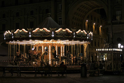 Illuminated carousel at park in night