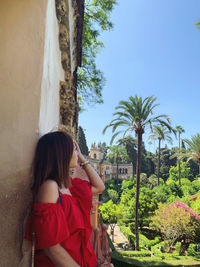 Rear view of woman with umbrella against trees