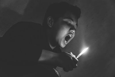 Portrait of young man smoking at night