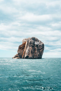 Rock formation in sea against sky