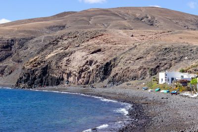 Scenic view of sea and mountains against sky