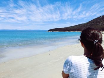 Rear view of woman looking at sea against sky