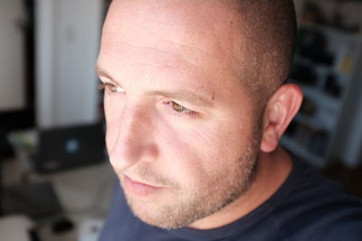 Close-up of thoughtful man looking away at home