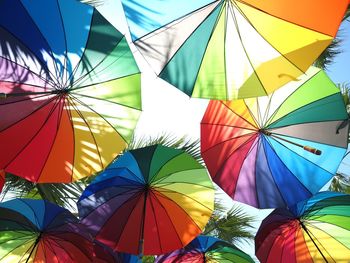 Low angle view of colorful umbrellas hanging against sky