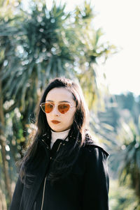 Portrait of beautiful woman in sunglasses against trees