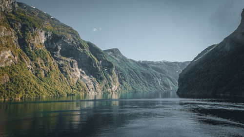 Scenic view of lake by mountains against sky