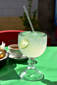 Large glass of lemonade with lime slice in glass served in restaurant in baja mexico 
