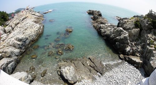 High angle view of rock formation in sea against sky