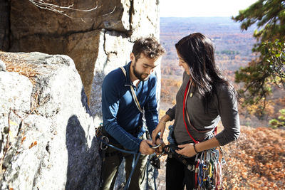 Man assisting girlfriend while rock climbing