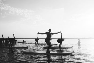 People at beach against sky