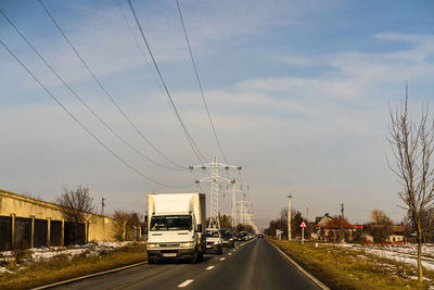 Cars on road against sky in city