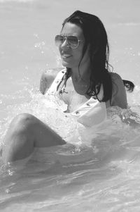 Young woman wearing sunglasses at sea shore