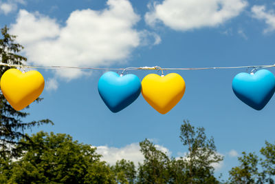 Garland in the form of yellow and blue hearts against the blue sky. 