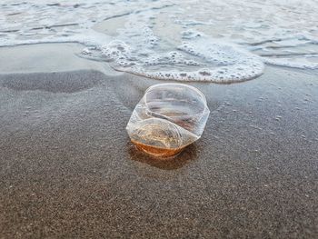 High angle view of plastic bottle on beach