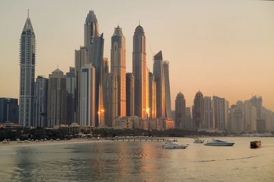 Skyscrapers in city at sunset