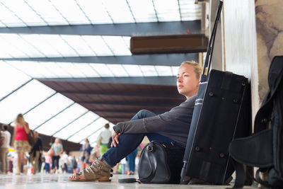Woman looking away while sitting at airport