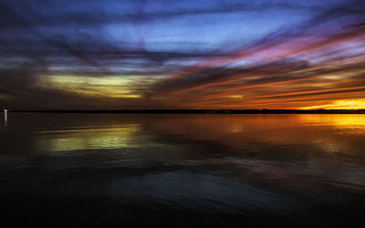 Scenic view of sea against dramatic sky during sunset