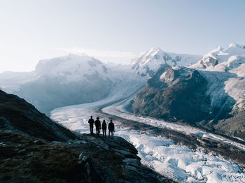 People standing against snowcapped mountain