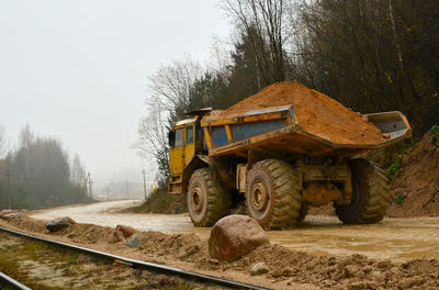 Built structure on field by road against sky during winter