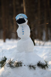 Snowman wearing protective face mask. covid19 and quarantin concept. snowman is in the forest