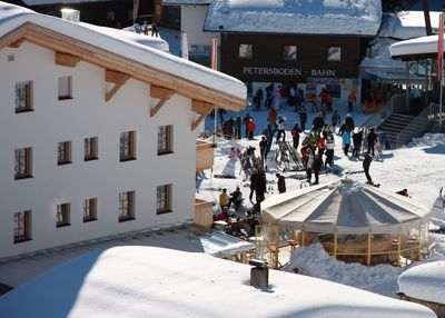 High angle view of people on snow by buildings