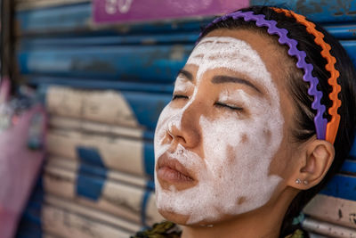 Close-up of woman with facial mask on face