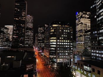 Illuminated buildings in city against sky at night