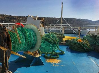 Fishing boats moored at harbor against clear blue sky
