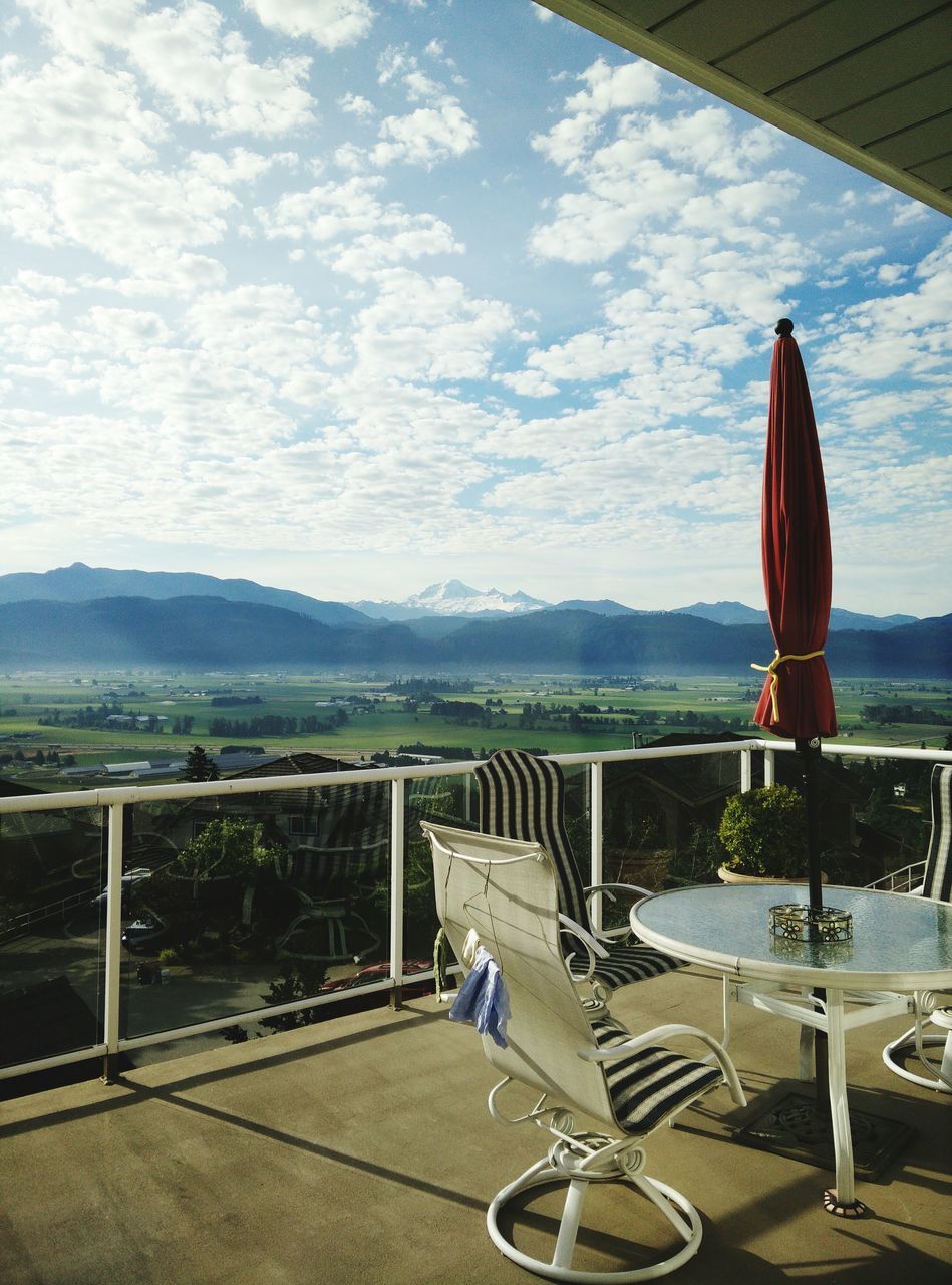 sky, mountain, cloud - sky, mountain range, cloud, rear view, leisure activity, lifestyles, men, sitting, water, day, transportation, nature, railing, table, landscape, casual clothing