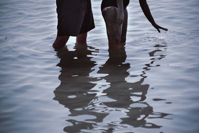 Midsection of people standing in water