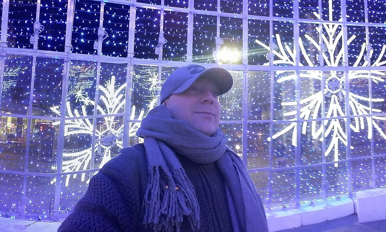 WOMAN STANDING IN SNOW COVERED WITH ILLUMINATED LIGHTS