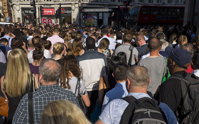 Rear view of people walking on street in city