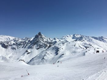 Scenic view of snowcapped mountains against clear blue sky
