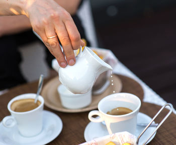 Midsection of person preparing coffee on table 