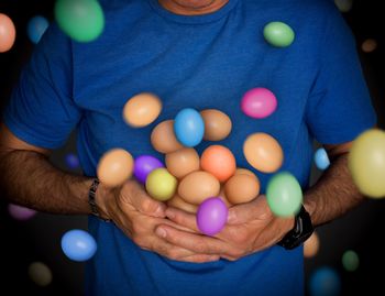 Midsection of man holding colorful easter eggs