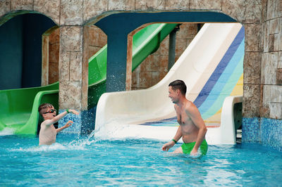 Happy boy with father enjoying in water park 