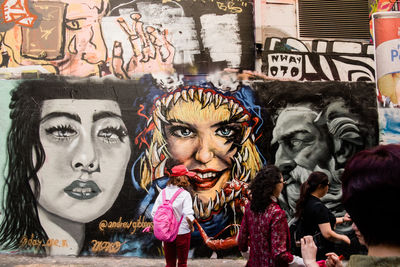 Portrait of people against graffiti wall