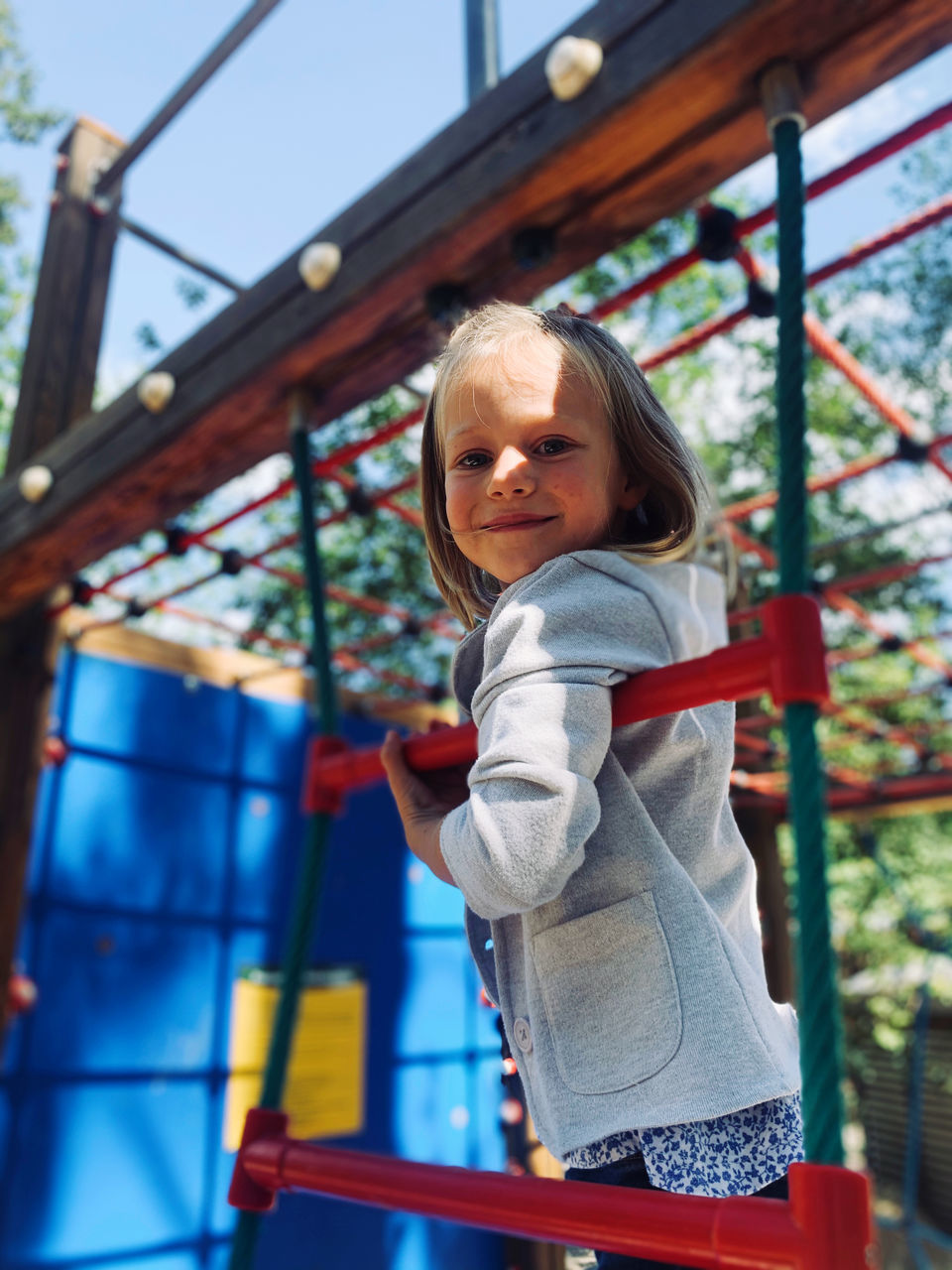 PORTRAIT OF CUTE GIRL STANDING ON PLAYGROUND
