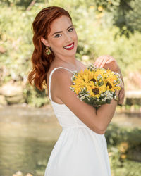Portrait of young woman holding flowers