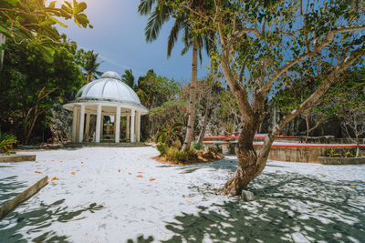 Gazebo by trees against sky during winter