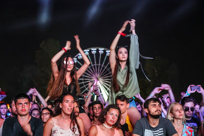 Group of people enjoying music concert at night