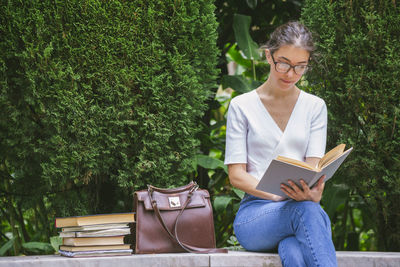 Young woman sitting on book