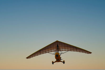 Low angle view of glider against clear sky during sunset