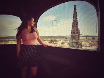 Full length of woman standing against sky in city