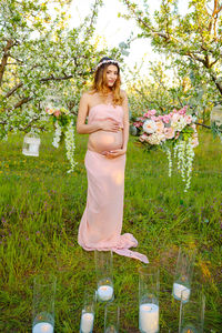 Portrait of smiling young woman standing against plants