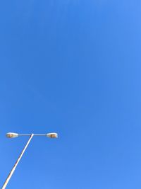 Low angle view of street light against blue sky