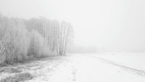 Snow covered field against clear sky