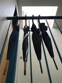Low angle view of umbrellas hanging from railing at home